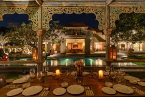 uma mesa preparada para um jantar em frente a uma piscina em Elivaas Oasis Luxury 6BHK with Pvt Pool, Sainik Farm New Delhi em Nova Deli