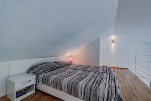 a white bedroom with a bed and a night stand at Vila Inga - Postira in Postira