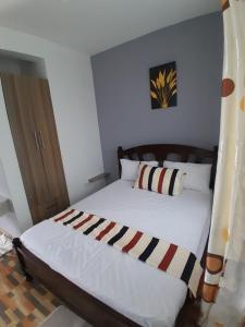 a bedroom with a bed with a striped blanket at Kelly Homes in Kilifi