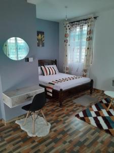 a bedroom with a bed and a chair and a mirror at Kelly Homes in Kilifi