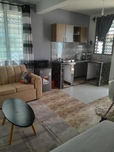 a living room with a couch and a kitchen at Kelly Homes in Kilifi