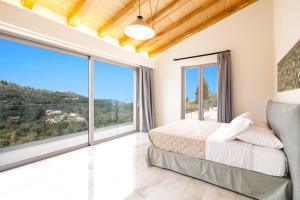 een slaapkamer met een bed en grote ramen bij Villa Tila by Villa Plus in Agnítsini +20 foto's