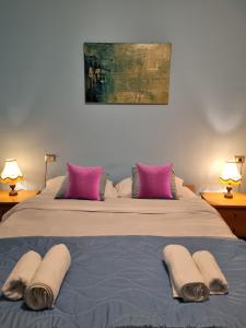 una camera con 2 letti con cuscini rosa e grigio di Sweet Dream a Passignano sul Trasimeno