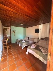 a room with three beds and a flat screen tv at Pousada Aláfia Sul in Una