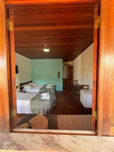 een persoon die op de vloer ligt in een kamer met twee bedden bij Pousada Aláfia Sul in Una