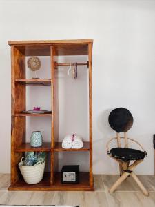a wooden book shelf with a chair in a room at Zanzibar Gem Beach Bungalows in Bwejuu