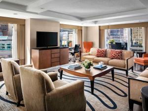 a living room with a couch and a television at Fairmont Waterfront in Vancouver