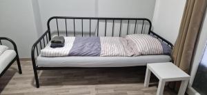 a black bed with pillows and a table in a room at APARTMENTS RATZERSDORFER SEEN in 3100 SANKT PÖLTEN in Sankt Pölten