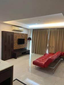 Il comprend un salon doté d'un canapé rouge et d'une télévision à écran plat. dans l'établissement Studio Exclusive (Kota Bharu City Point), à Kota Bharu
