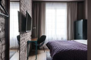 a bedroom with a bed and a desk with a chair at Story Hotel Signalfabriken, part of JdV by Hyatt in Sundbyberg