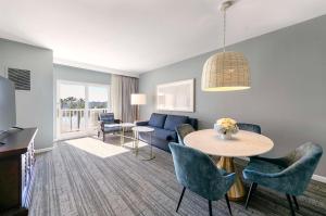 a living room with a blue couch and a table at Jamaica Bay Inn Marina Del Rey Tapestry Collection by Hilton in Los Angeles