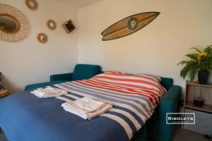 łóżko z ręcznikami i deską surfingową na ścianie w obiekcie T2 climatisé avec WIFI et piscine w mieście Vias +37 zdjęć