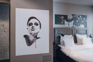 a black and white picture of a woman next to a bed at Story Hotel Signalfabriken, part of JdV by Hyatt in Sundbyberg
