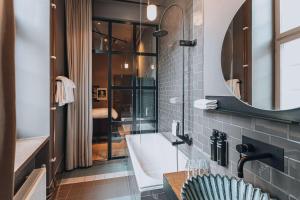uma casa de banho com um lavatório e um espelho em Story Hotel Signalfabriken, part of JdV by Hyatt em Sundbyberg