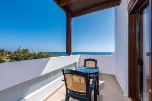 a balcony with two chairs and a view of the ocean at Villa Kiotari by Villa Plus in Kiotari