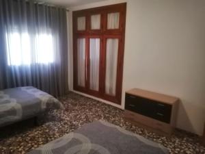 1 dormitorio con 1 cama, TV y ventana en Señora Isabel, en Roquetas de Mar