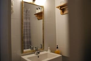 ein Bad mit einem Waschbecken und einem Spiegel in der Unterkunft Maalaishotelli Hanna&Magnus in Merikarvia
