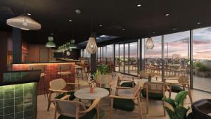 ein Restaurant mit Tischen und Stühlen in der Unterkunft Hilton Garden Inn Debrecen City Centre in Debrecen