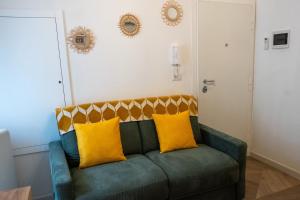 a green couch with yellow pillows in a room at Bari in un click in Bari