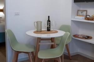 a table with two chairs and a bottle of wine at Bari in un click in Bari