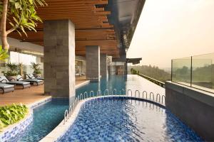 einem Infinity-Pool in der Mitte eines Gebäudes in der Unterkunft Doubletree By Hilton Jakarta Bintaro Jaya in Serpong