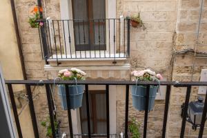 a balcony with two flower pots on a railing at Bari in un click in Bari