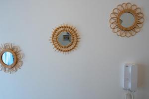 three mirrors on a white wall with a phone at Bari in un click in Bari