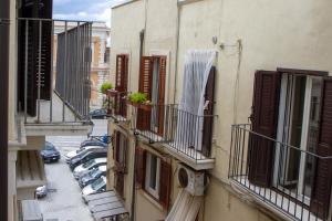an alley between two buildings with balconies and cars at Bari in un click in Bari