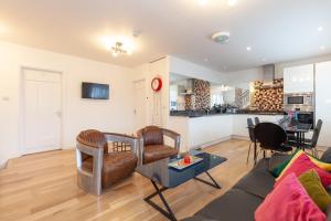 a living room with a couch and chairs and a kitchen at 23 Wharton Road in Oxford