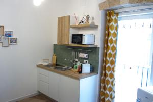 a small kitchen with a sink and a microwave at Bari in un click in Bari