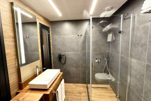 a bathroom with a shower and a sink and a toilet at FT Lotus Thermal Hotel&SPA Trademark Collection by Wyndham in Menemen