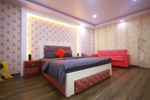 a bedroom with a bed and a red couch at Raj Resort in Patna