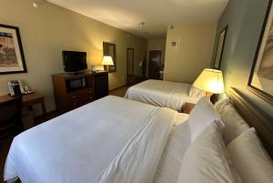 a hotel room with two beds and a television at Wingate by Wyndham Newell in Newell