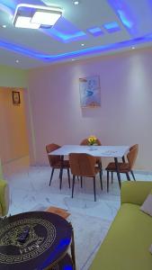 Cette chambre est dotée d'une table, de chaises et d'un plafond bleu. dans l'établissement BOSSLIFE APARTMENTS-TERMINUS SAINT MICHEL DERRIERE Barcelone Hôtel, à Douala
