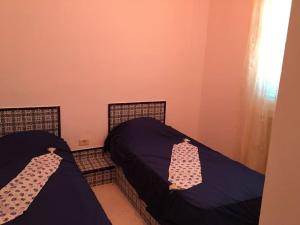 two beds in a room with purple sheets at 3 Bedrooms appartment in Nabeul