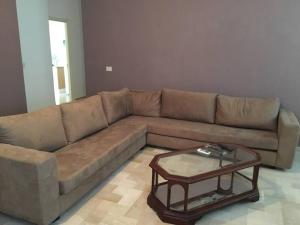 a brown couch in a living room with a table at 3 Bedrooms appartment in Nabeul