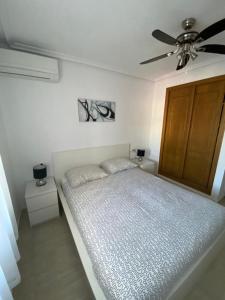 een slaapkamer met een bed en een plafondventilator bij Ground floor apartment Torrevieja Spain in Orihuela