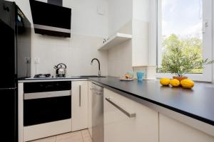 eine Küche mit schwarzen und weißen Geräten und einem Fenster in der Unterkunft Beautiful & Modern Apartment near the City Center by Renters in Warschau