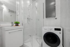 eine Waschmaschine im Bad mit Dusche in der Unterkunft Beautiful & Modern Apartment near the City Center by Renters in Warschau