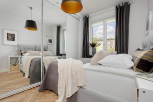 1 Schlafzimmer mit 2 Betten und einem Spiegel in der Unterkunft Beautiful & Modern Apartment near the City Center by Renters in Warschau