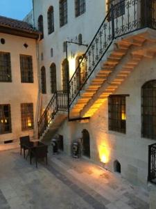 un edificio con una escalera y un piano en un patio en aynur hanım konağı butik otel, en Şahinbey