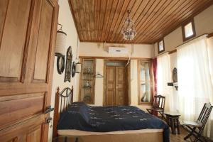 een slaapkamer met een bed en een houten plafond bij aynur hanım konağı butik otel in Şahinbey