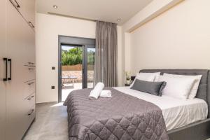 a bedroom with a large bed and a balcony at Villa Casa Liveris by Villa Plus in Akrotiri +17 photos