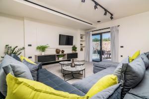 a living room with a blue couch and yellow pillows at Villa Casa Liveris by Villa Plus in Akrotiri