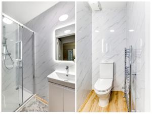 ein weißes Bad mit einer Dusche und einem WC in der Unterkunft Contractors Families M25 Royal Vet College Free Parking in Potters Bar