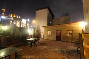 un patio con una mesa y un edificio por la noche en aynur hanım konağı butik otel, en Şahinbey