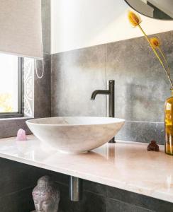 a bathroom with a white bowl sink on a counter at Relaxing Burleigh Heads Home with Swimming Pool in Gold Coast