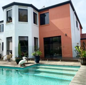 une maison avec une piscine en face d'une maison dans l'établissement Relaxing Burleigh Heads Home with Swimming Pool, à Gold Coast