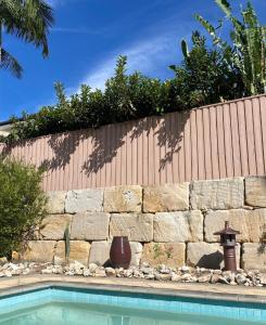 un mur en pierre à côté d'une piscine dans l'établissement Relaxing Burleigh Heads Home with Swimming Pool, à Gold Coast