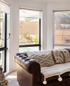 - un salon avec un canapé et 2 fenêtres dans l'établissement Relaxing Burleigh Heads Home with Swimming Pool, à Gold Coast
